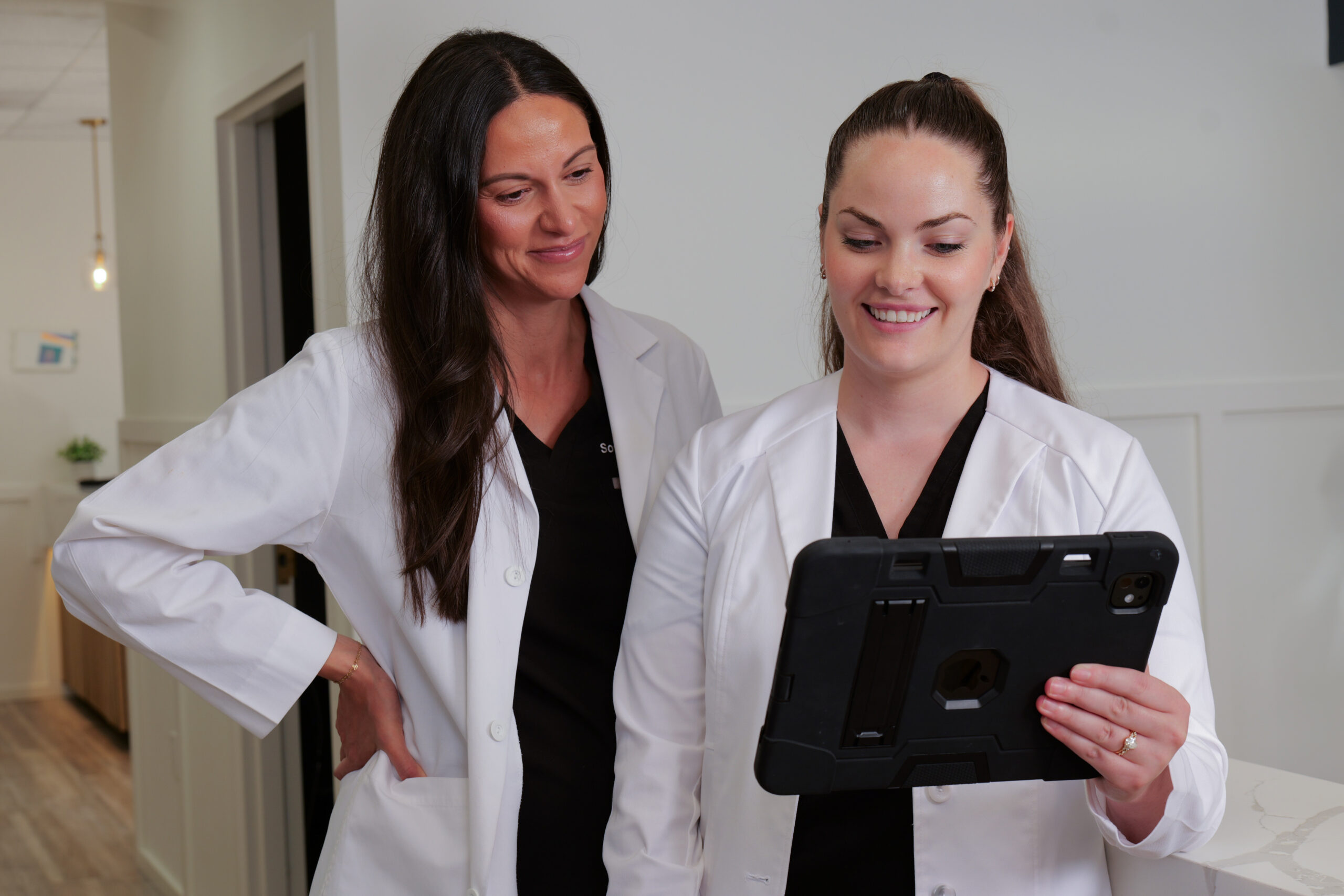 Two Medical Professionals Reviewing Patient Information On Tablet - Goodluckstef Productions
